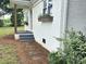 View of front door with planter boxes, stone walkway, gray steps and dark wooden posts at 13131 601 S Hwy, Midland, NC 28107