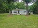 Charming single-story home with white brick, dark door and window boxes nestled among mature trees at 13131 601 S Hwy, Midland, NC 28107