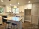 Modern kitchen features an island with seating, stainless steel appliances, and bright overhead lighting at 13131 601 S Hwy, Midland, NC 28107