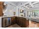 Stylish bar area featuring granite countertops, custom cabinetry, wine cooler, and seamless integration with living spaces at 15909 Heath Aster Way, Davidson, NC 28036