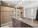 Bathroom features a granite countertop, dark cabinets, and glass-enclosed tiled shower at 15909 Heath Aster Way, Davidson, NC 28036