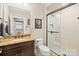 Bathroom features a dark vanity with a granite countertop and a glass enclosed shower at 15909 Heath Aster Way, Davidson, NC 28036