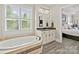 This bathroom features an elegant soaking tub, tile floors, and a stone countertop vanity at 15909 Heath Aster Way, Davidson, NC 28036