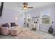 Bedroom features a cozy sitting area, desk and makeup vanity, natural light, and ceiling fan at 15909 Heath Aster Way, Davidson, NC 28036
