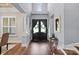 Bright foyer with hardwood floors, high ceiling, and elegant front door featuring custom glass work and sidelight windows at 15909 Heath Aster Way, Davidson, NC 28036
