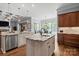 Gourmet kitchen featuring double islands, granite counters, and hardwood floors with view into living room at 15909 Heath Aster Way, Davidson, NC 28036
