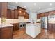 Gourmet kitchen featuring stone backsplash, granite countertops, stainless appliances, and hardwood floors at 15909 Heath Aster Way, Davidson, NC 28036