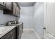 Functional laundry room includes gray cabinets, washer and dryer, and utility sink at 15909 Heath Aster Way, Davidson, NC 28036