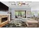 Cozy living room with a fireplace, access to screened porch, and ample natural light at 15909 Heath Aster Way, Davidson, NC 28036
