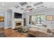 Inviting living room featuring a cozy stone fireplace, coffered ceilings, and access to a screened porch at 15909 Heath Aster Way, Davidson, NC 28036