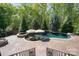 Relaxing backyard pool with mature trees, a hot tub, and an outdoor entertaining area at 15909 Heath Aster Way, Davidson, NC 28036
