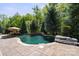 Beautiful pool with rock accents surrounded by a stamped concrete patio and mature trees at 15909 Heath Aster Way, Davidson, NC 28036