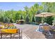 Expansive outdoor patio with dining and lounge areas overlooking a stunning pool and lush greenery at 15909 Heath Aster Way, Davidson, NC 28036