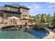 Gorgeous backyard pool with waterfall feature, sun loungers, and a beautiful outdoor setting at 15909 Heath Aster Way, Davidson, NC 28036