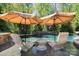 Inviting poolside loungers under umbrellas by a refreshing pool surrounded by lush greenery at 15909 Heath Aster Way, Davidson, NC 28036