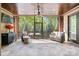Relaxing screened porch with a stone tile floor, ceiling fan, and views of the backyard and mature trees at 15909 Heath Aster Way, Davidson, NC 28036
