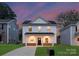 Charming two-story home featuring a covered front porch and a well-maintained lawn at dusk at 1841 Bear St, Charlotte, NC 28213