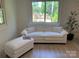 Bright living room featuring a white sofa, ottoman, and a large window with outside views at 188 Bailey Rd, Mooresville, NC 28117