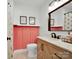 Bright bathroom featuring coral accent wall, modern vanity with black hardware, and decorative mirror at 2008 Faulkner Rd, Clover, SC 29710