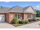 Side exterior view of a red brick home with well-maintained landscaping and a two-car garage at 2334 Sylvia Ct, Denver, NC 28037