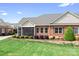 The exterior of this red brick home is complemented by a lush green lawn and blue sky at 2334 Sylvia Ct, Denver, NC 28037