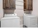 Laundry room with white washer and dryer, and dark wooden cabinets above laundry units at 2334 Sylvia Ct, Denver, NC 28037