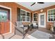 A cozy outdoor porch features brick accents, comfortable seating, and a tranquil view at 2334 Sylvia Ct, Denver, NC 28037