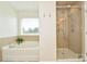 Bathroom showcasing a soaking tub, a glass shower, and modern fixtures at 235 Whispering Hills Dr, Locust, NC 28097