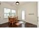 Bright breakfast nook features a wooden table and chairs, hardwood floors, and a door to the exterior at 235 Whispering Hills Dr, Locust, NC 28097