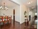 Open-concept dining room featuring hardwood floors, a chandelier, and ample space for Gathering gatherings and entertaining at 235 Whispering Hills Dr, Locust, NC 28097