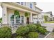 Charming two-story home featuring a welcoming front porch with stone accents and a well-manicured front yard at 235 Whispering Hills Dr, Locust, NC 28097