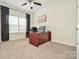 Bright home office with a large window, neutral carpeting, and a sleek desk setup at 235 Whispering Hills Dr, Locust, NC 28097