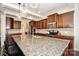 Gourmet kitchen showcasing granite countertops, custom cabinetry, a large center island with seating and pendant lighting at 235 Whispering Hills Dr, Locust, NC 28097