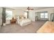 Main bedroom boasts plush carpeting, a sitting area, and a decorative ceiling fan with light at 235 Whispering Hills Dr, Locust, NC 28097