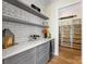 Elegant pantry with gray cabinets, quartz countertops, subway tile backsplash, and wine fridge at 2500 Marshall Pl, Charlotte, NC 28203