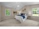 Bright bedroom with a chandelier, neutral paint and carpet, and two windows at 2848 Briar Ridge Dr, Charlotte, NC 28270