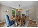 Bright dining room featuring a wooden table, six chairs, a modern light fixture, and a large window at 2848 Briar Ridge Dr, Charlotte, NC 28270