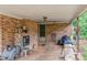 Covered back porch with brick fireplace, concrete floor, and door leading to the backyard at 302 Kimberlee Dr, Shelby, NC 28152