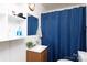 Functional bathroom with a vanity, mirror, and a shower with blue curtain, providing essential amenities at 311 Airport Rd, Rock Hill, SC 29732