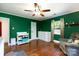 The green bedroom features a ceiling fan, hardwood floors, one window, a dresser and easy chair at 311 Airport Rd, Rock Hill, SC 29732