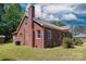 Side exterior view of a red brick home with a large chimney and well-maintained lawn at 311 Airport Rd, Rock Hill, SC 29732