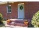 Inviting front porch featuring brick steps, potted flowers, and a wreath on the door of a traditional-style brick home at 311 Airport Rd, Rock Hill, SC 29732