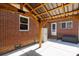 Covered patio with exposed wooden support beams, brick wall, string lights, and concrete floor at 311 Airport Rd, Rock Hill, SC 29732