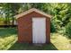 Red brick storage shed with a white door surrounded by greenery at 311 Airport Rd, Rock Hill, SC 29732