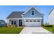 Charming one-story home with light blue siding, white trim, and a two-car garage on a well-manicured lawn at 355 Gray Wolf St # 122P, China Grove, NC 28023