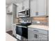 Close-up of kitchen features, with stainless steel appliances, gray subway tile backsplash, and modern gray cabinets at 355 Gray Wolf St # 122P, China Grove, NC 28023