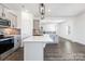 Stylish kitchen with gray cabinets, stainless steel appliances, gray backsplash and a large island overlooking the living area at 355 Gray Wolf St # 122P, China Grove, NC 28023