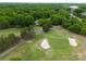 Aerial view of the home nestled among lush green trees, backing onto a golf course with sand bunkers at 3619 Chilham Pl, Charlotte, NC 28226