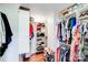 Organized walk-in closet with built-in shelving for shoes, folded clothes, and hanging garments at 3619 Chilham Pl, Charlotte, NC 28226
