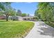 Ranch home with a curved driveway, lush lawn, and blue skies surrounded by mature trees at 3619 Chilham Pl, Charlotte, NC 28226